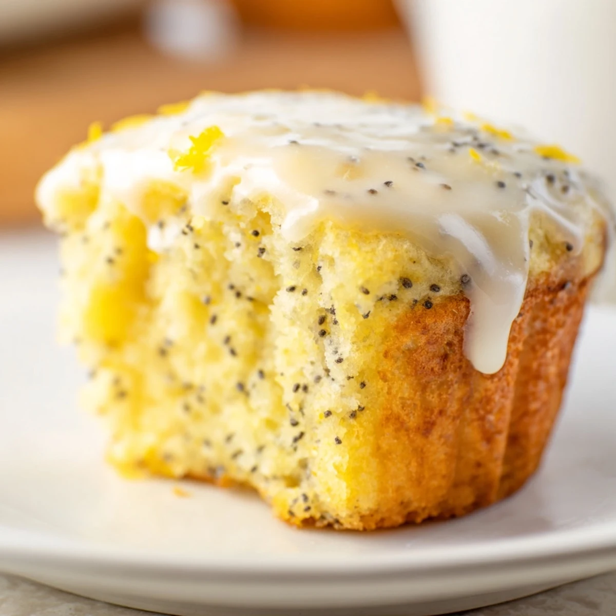 Golden-brown Lemon Poppy Seed Muffins with a glistening lemon glaze, perfect for a sunny breakfast.