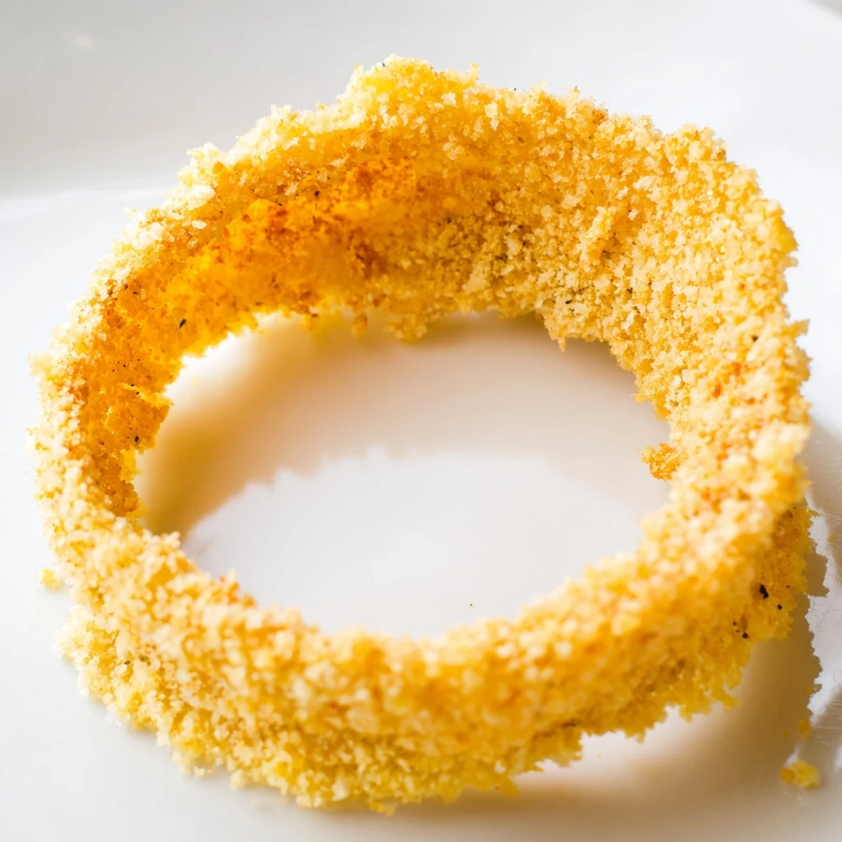 Freshly baked Crispy Baked Onion Rings with a golden panko-Parmesan crust, served hot on a baking sheet.