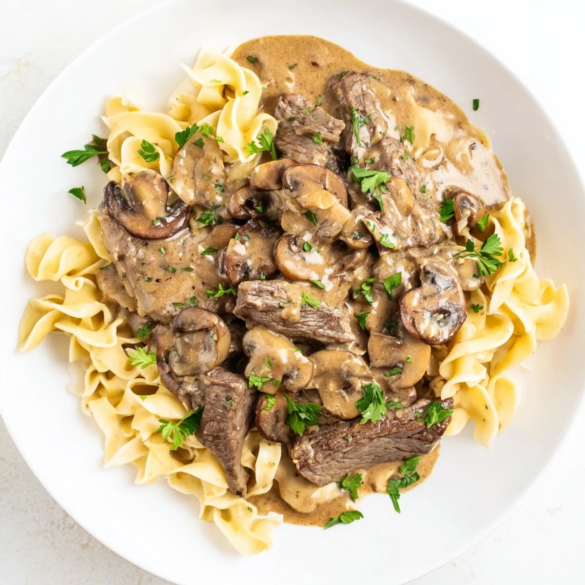 Hearty Beef Stroganoff with Mushroom Gravy steaming in a skillet, ready to serve with egg noodles or rice.