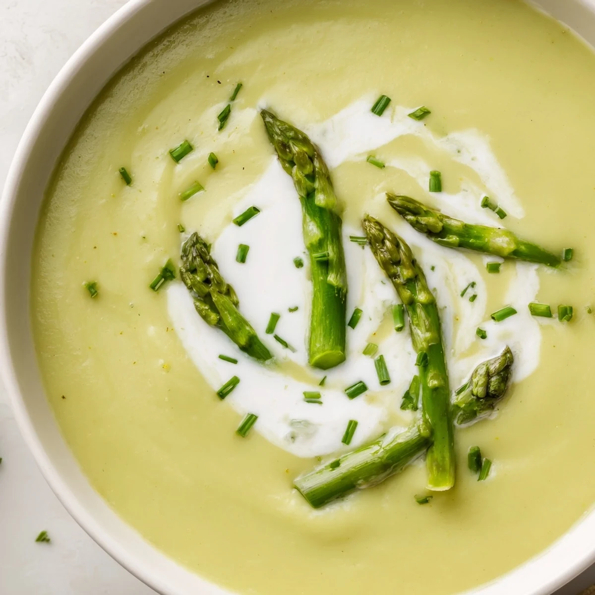 Vibrant green Creamy Asparagus Soup with Lemon pureed until silky smooth, ready to serve as a light, elegant starter for a dinner party.