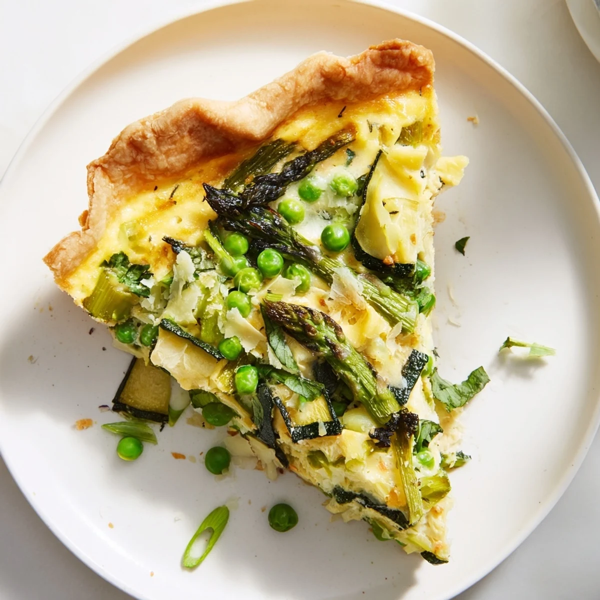 Spring Vegetable Quiche with Crust sits on a rustic wooden table, garnished with fresh herbs and a side salad for a perfect brunch meal.