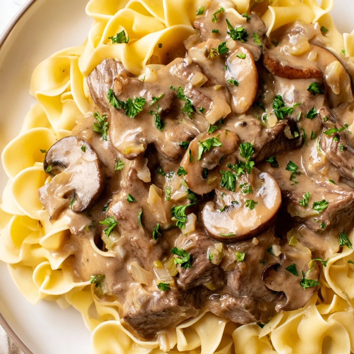 Close-up of Beef Stroganoff over Egg Noodles featuring tender beef strips and golden noodles.