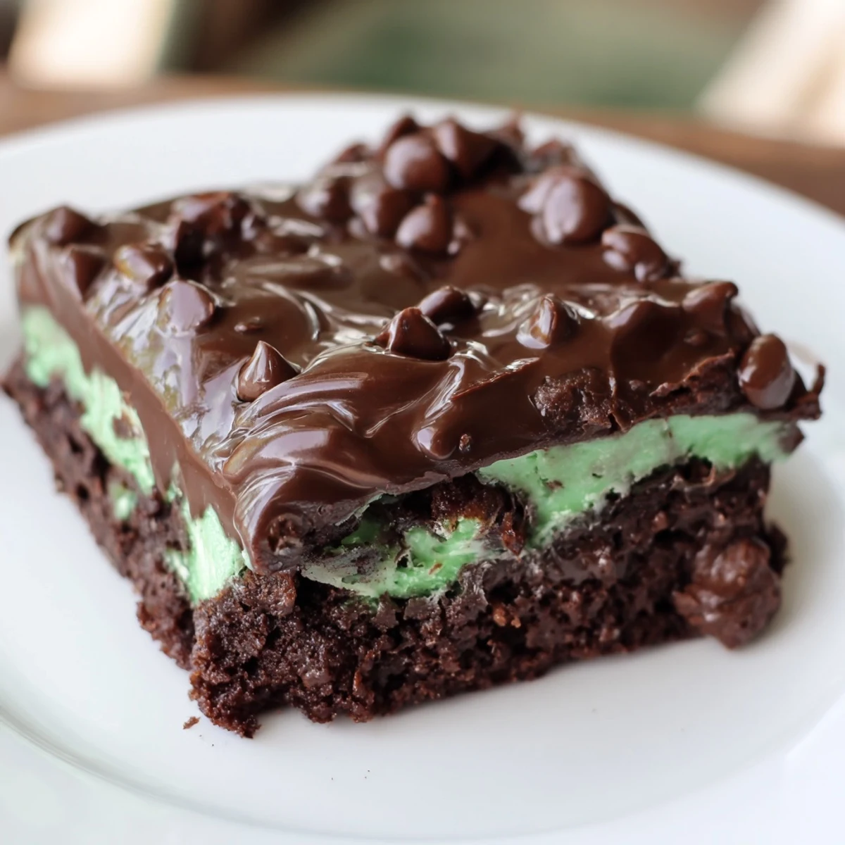 Fudgy Mint Chocolate Chip Brownies with melted chocolate topping and vibrant green mint layer.