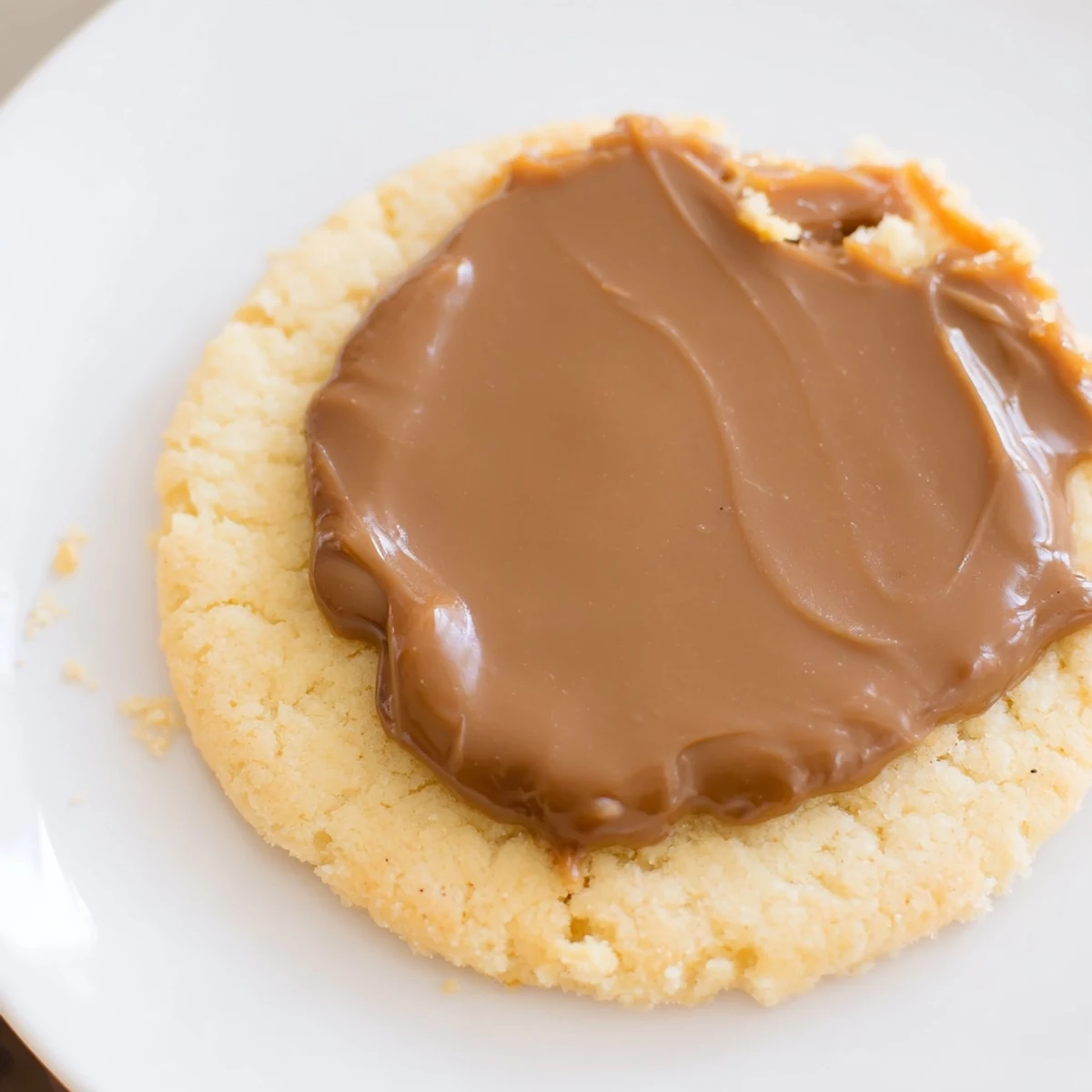 Buttery shortbread base for Twix Cookies topped with creamy caramel and glossy milk chocolate.