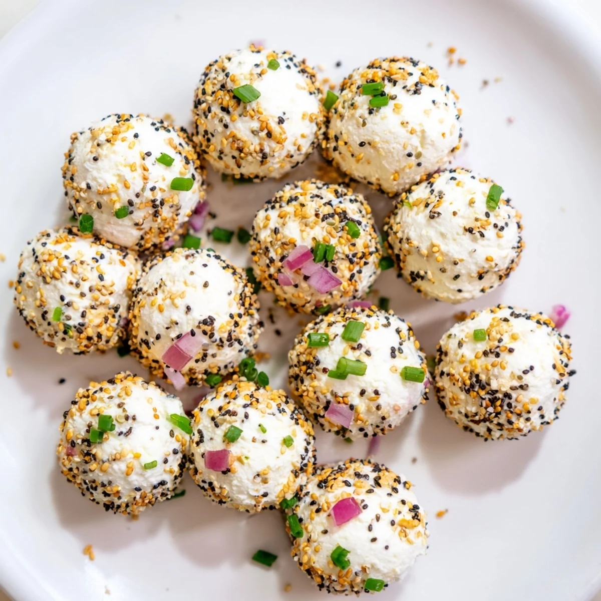 A close-up view of creamy Everything Bagel Cottage Cheese Bites with chives and red onion.