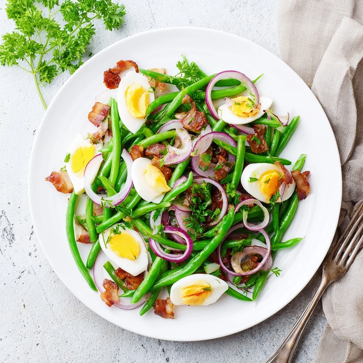 A close-up of the Green Bean, Bacon, and Egg Salad reveals chunks of smoky bacon and tender eggs tossed in a glossy Dijon vinaigrette.