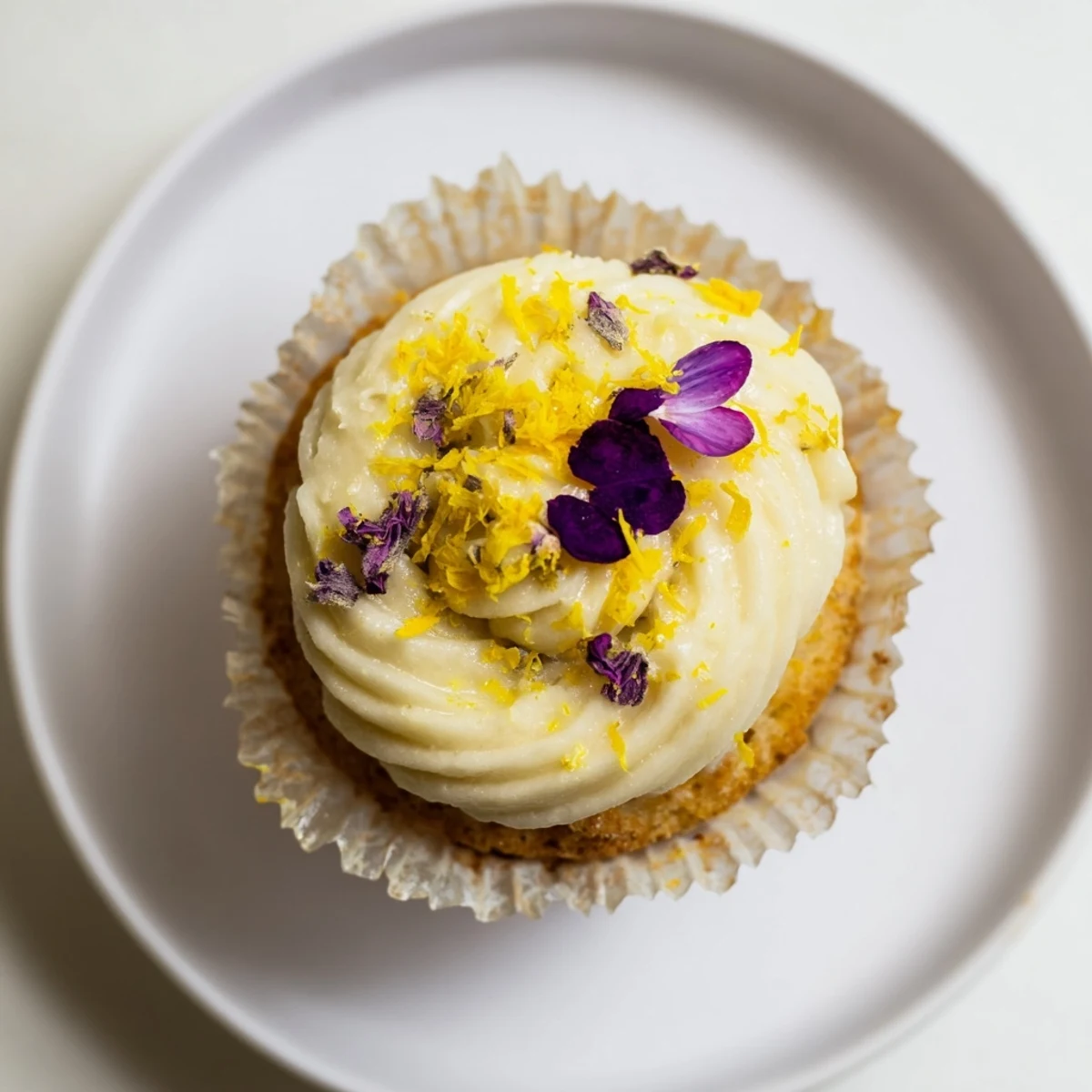 Twelve delicate elderflower cupcakes topped with creamy buttercream and edible flowers for a spring gathering.