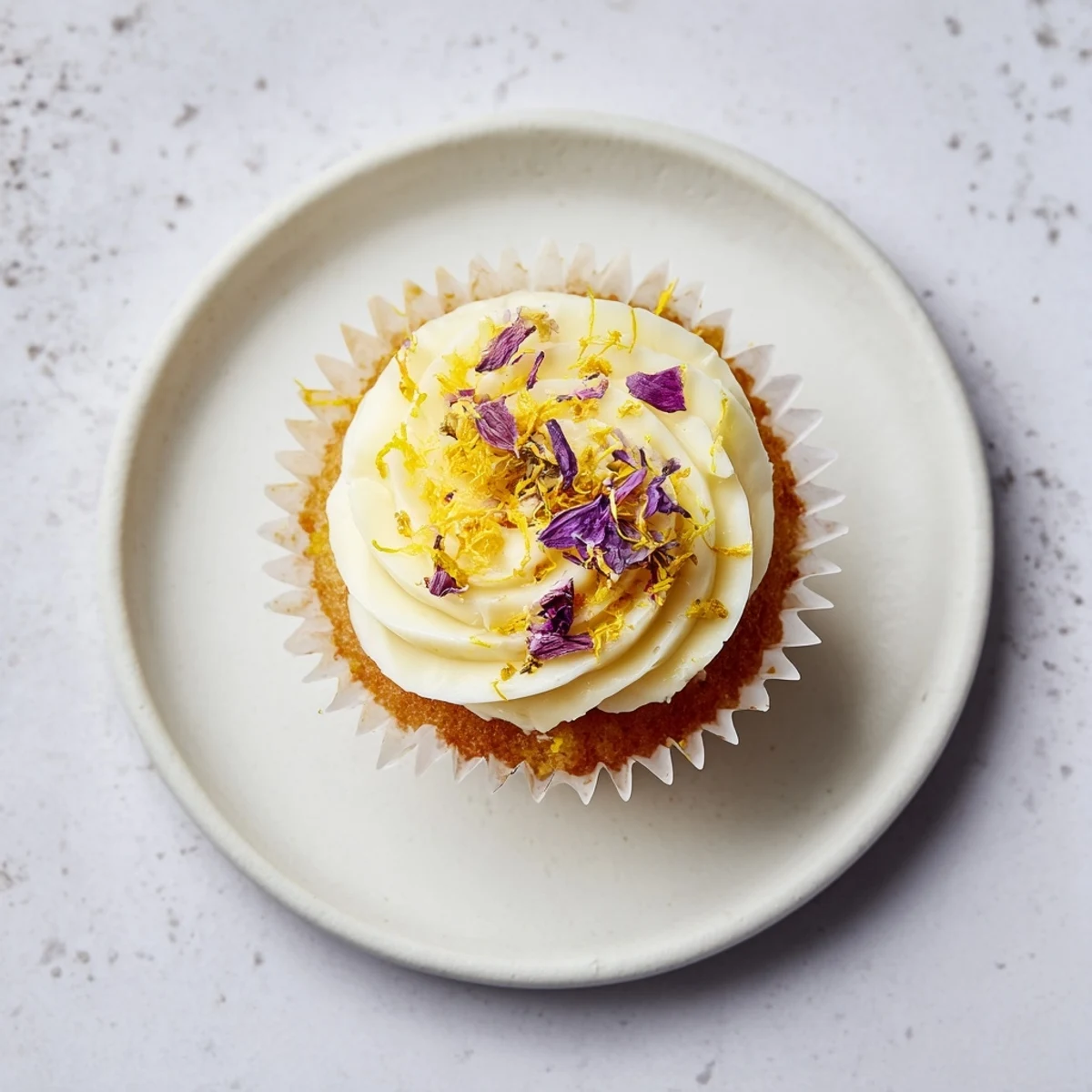 Golden-brown elderflower cupcakes brushed with syrup, showcasing fluffy crumb and floral buttercream swirl.
