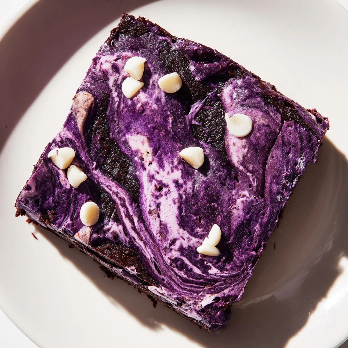 Fudgy ube brownies swirled with melted chocolate on a white plate