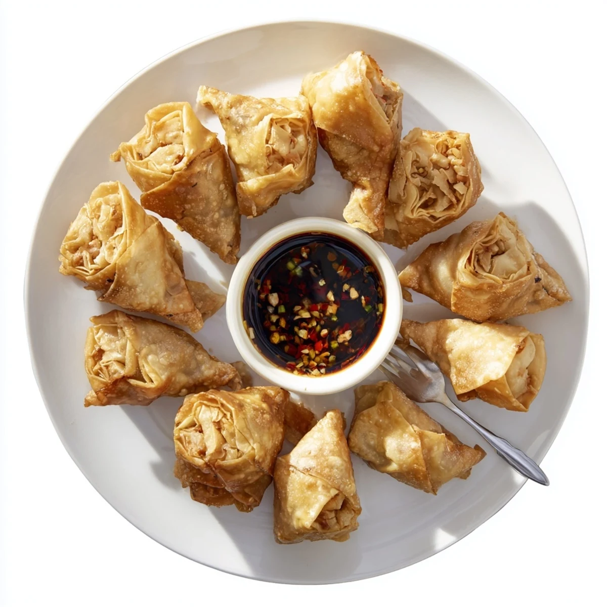 Vegetable-packed air fryer spring rolls arranged on white plate with small bowl of chili soy dipping sauce