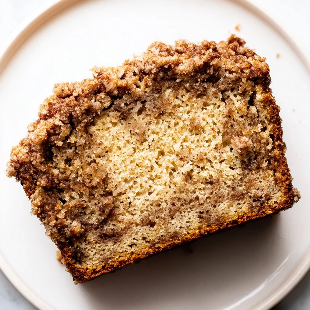Freshly baked cinnamon crumb banana bread loaf cooling on a wire rack