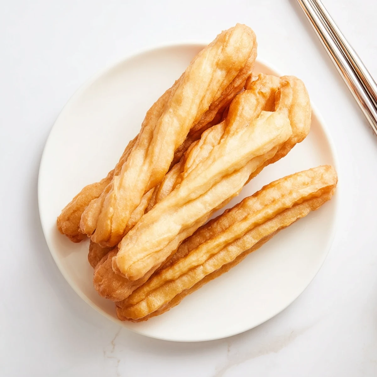Golden deep-fried Youtiao Chinese doughnuts with crispy exterior and fluffy white interior