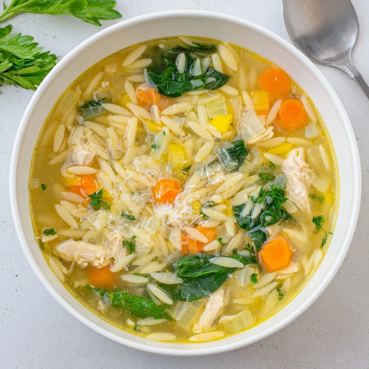Comforting chicken orzo soup featuring spring vegetables and zesty lemon in a warm savory broth