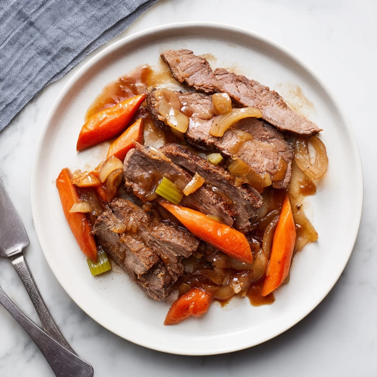 Succulent slow cooker beef brisket slices resting on a bed of tender carrots and onions with rich glossy sauce