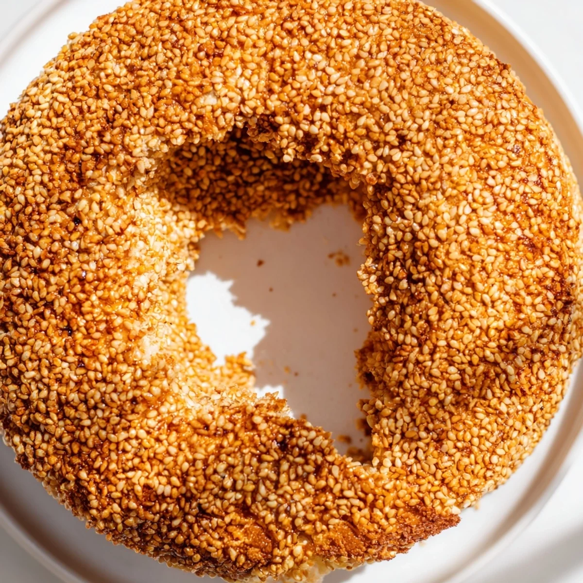Freshly baked sesame bread rings with crisp crusts and soft interiors cooling on wire rack