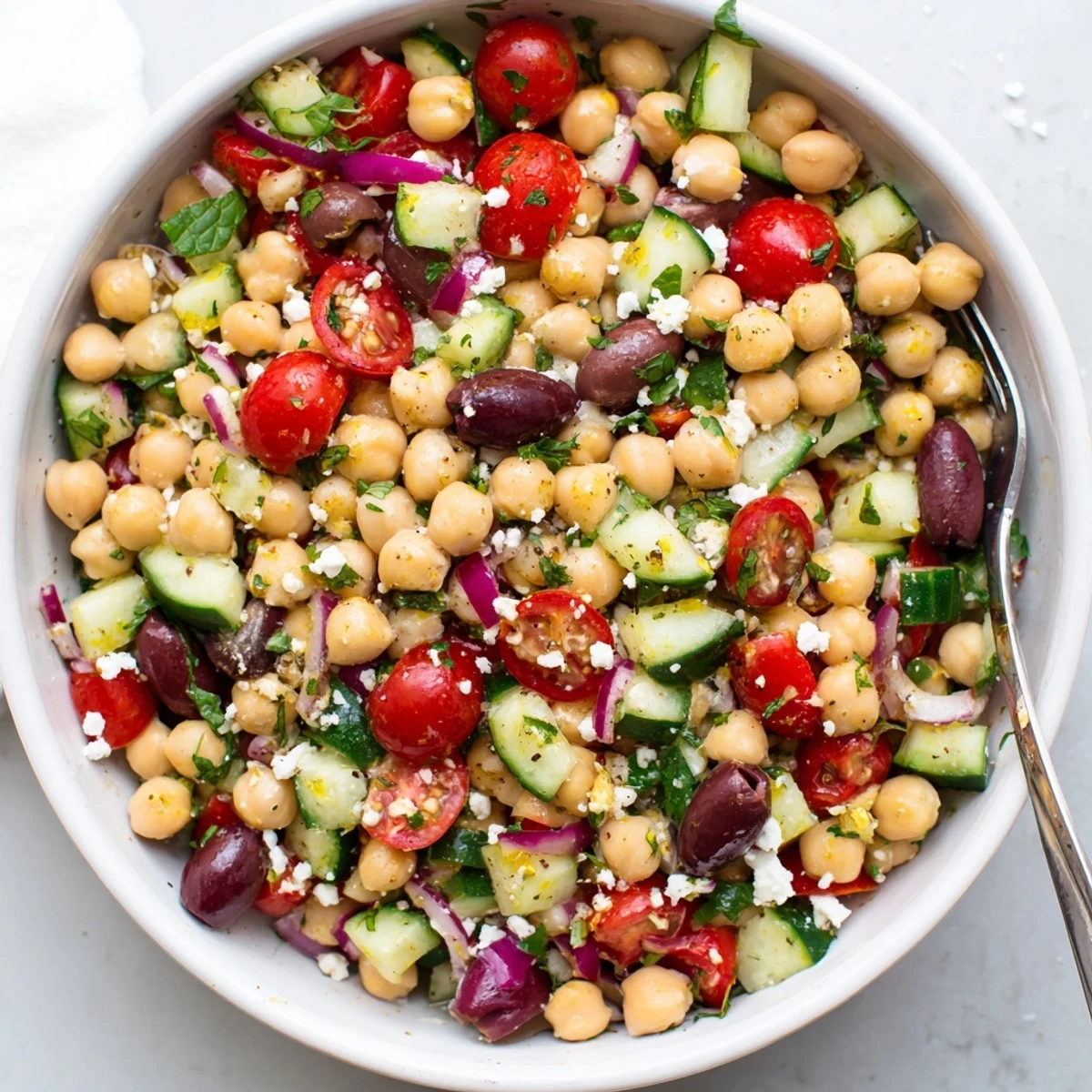 Fresh Mediterranean chickpea salad featuring crisp cucumbers, tomatoes, and parsley tossed in zesty olive oil