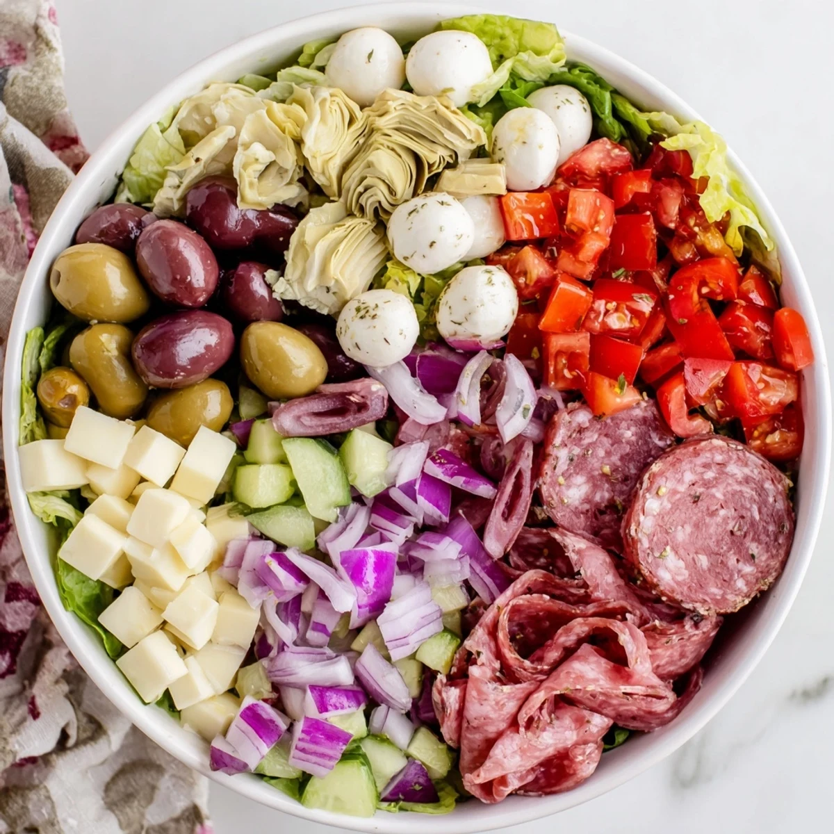Colorful antipasti chopped salad bowl with fresh vegetables, olives, and Italian cheeses