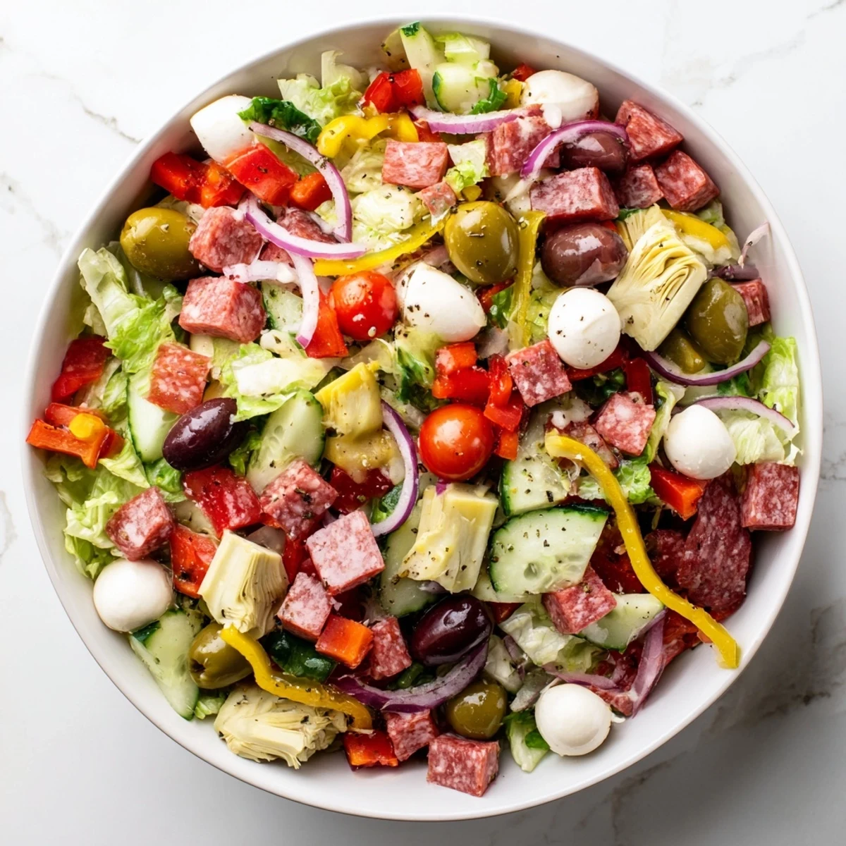 Fresh Italian antipasti salad featuring crisp radicchio, tomatoes, and marinated artichoke hearts