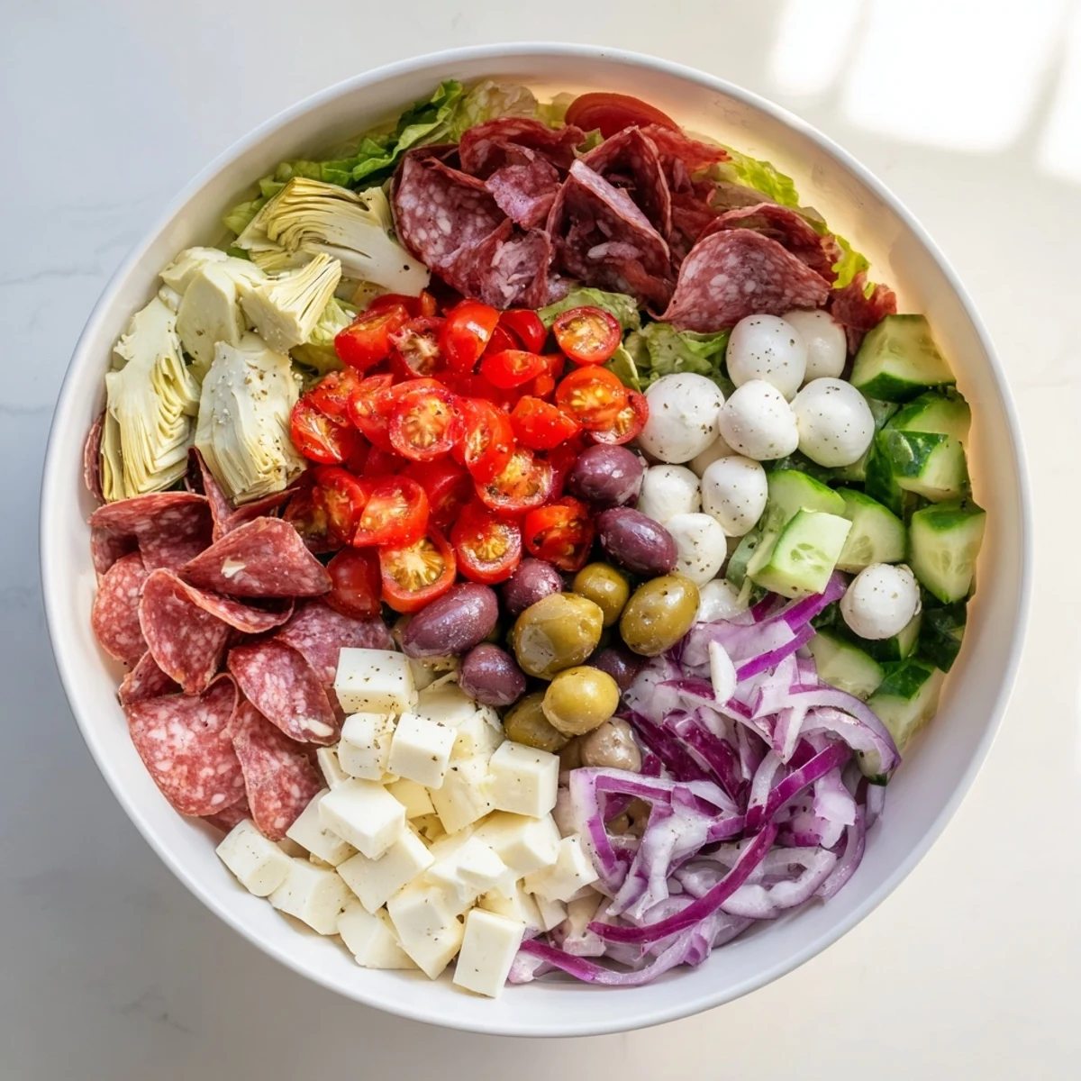 Vibrant chopped salad with cured meats, mozzarella balls, and roasted red peppers