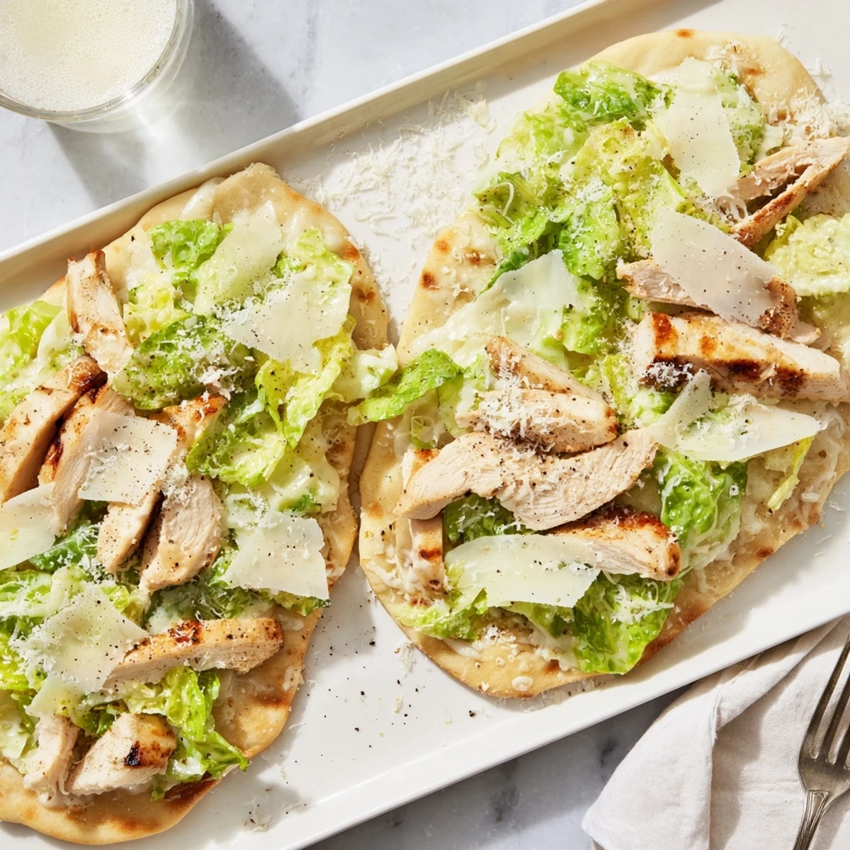 Golden chicken Caesar flatbread topped with crisp romaine lettuce and melted mozzarella cheese