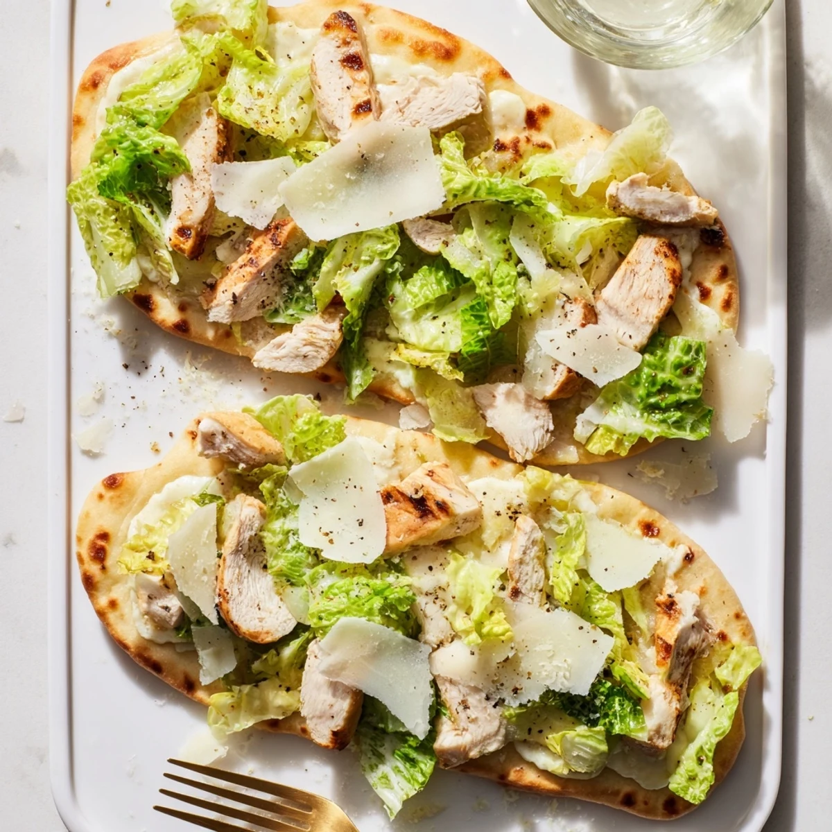 Homemade chicken Caesar flatbread with juicy seasoned chicken and crisp dressed romaine lettuce