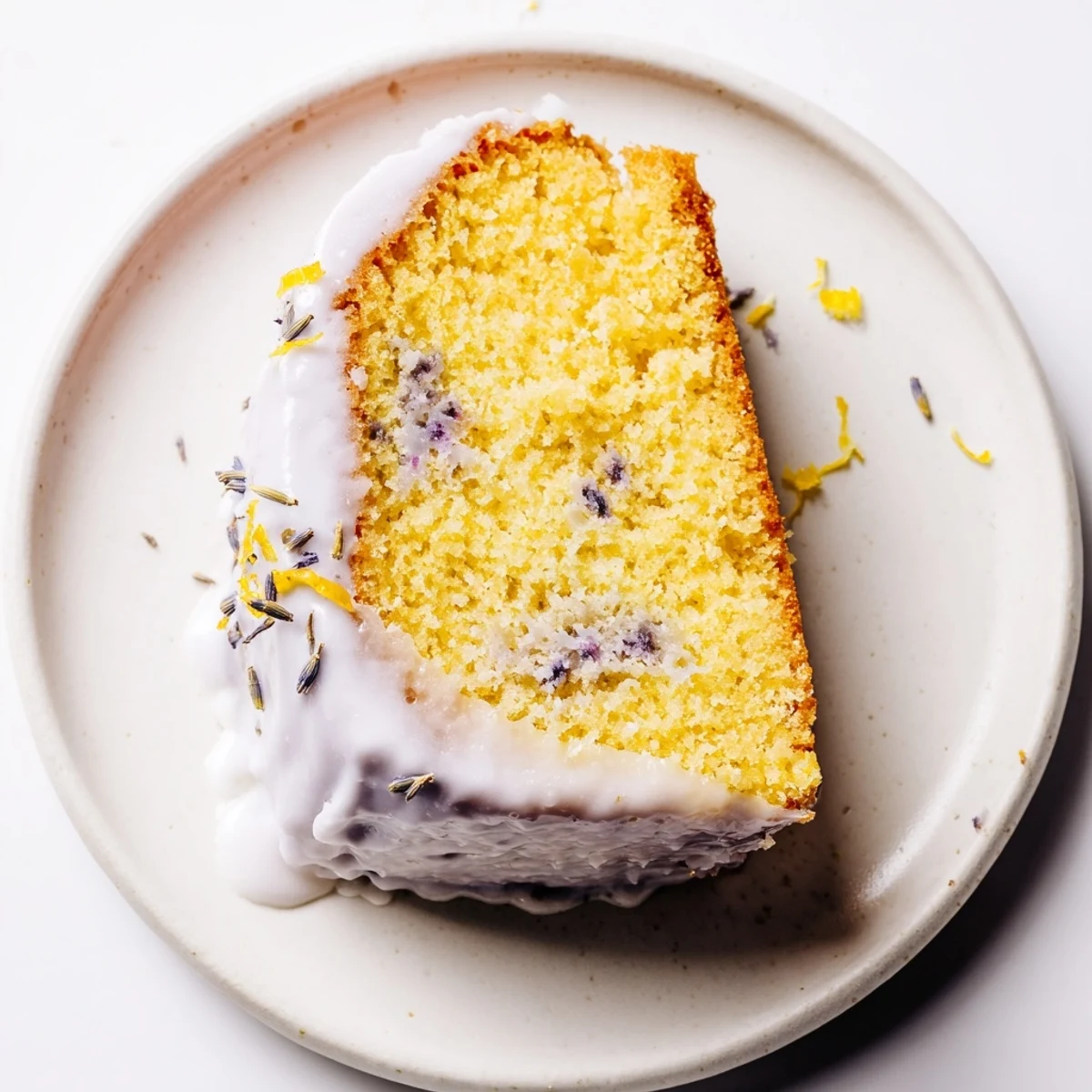 Soft lavender cake slice on a vintage plate, topped with sweet citrus icing