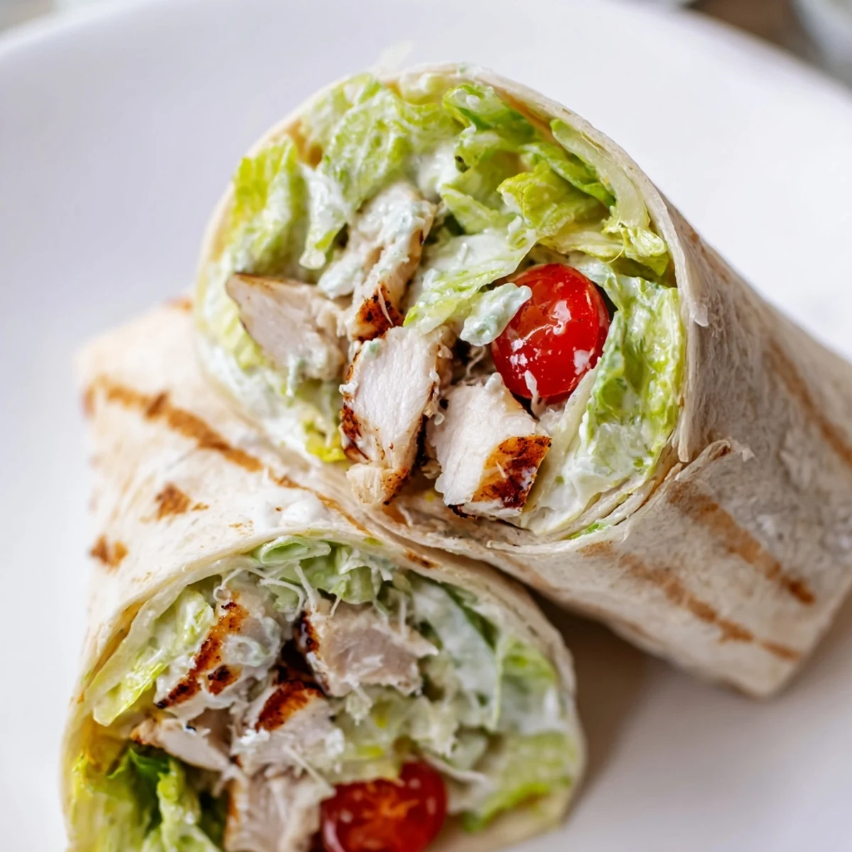 Chicken Caesar wraps sliced to reveal tender strips Parmesan and fresh green lettuce inside