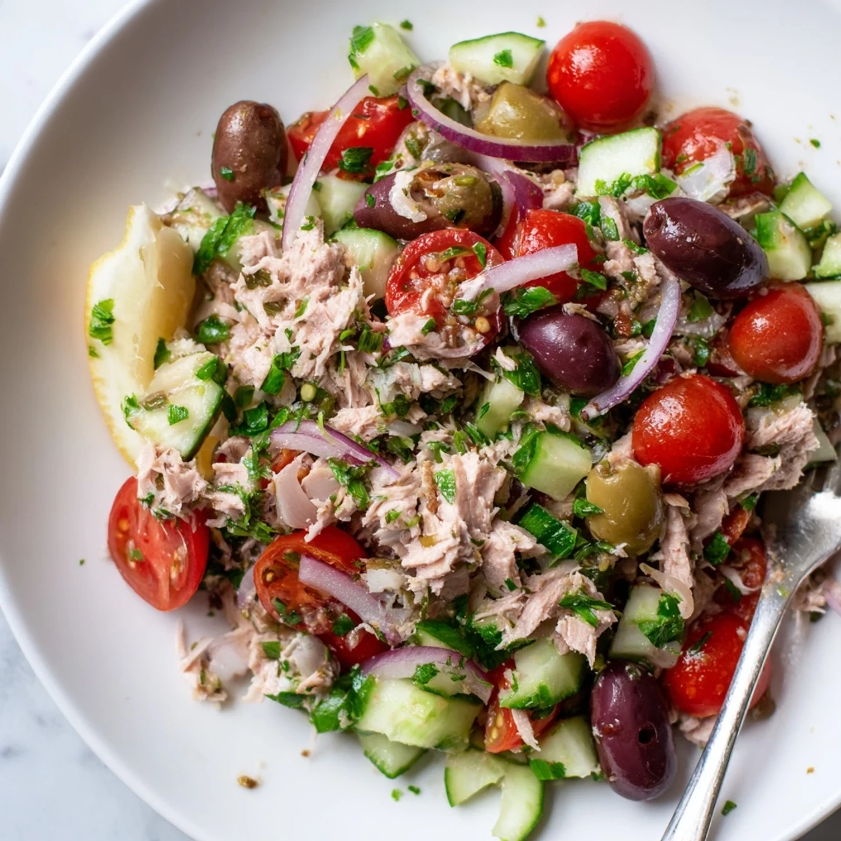 A vibrant bowl of Simple Mediterranean Tuna Salad with crisp cucumber, peppers, and capers