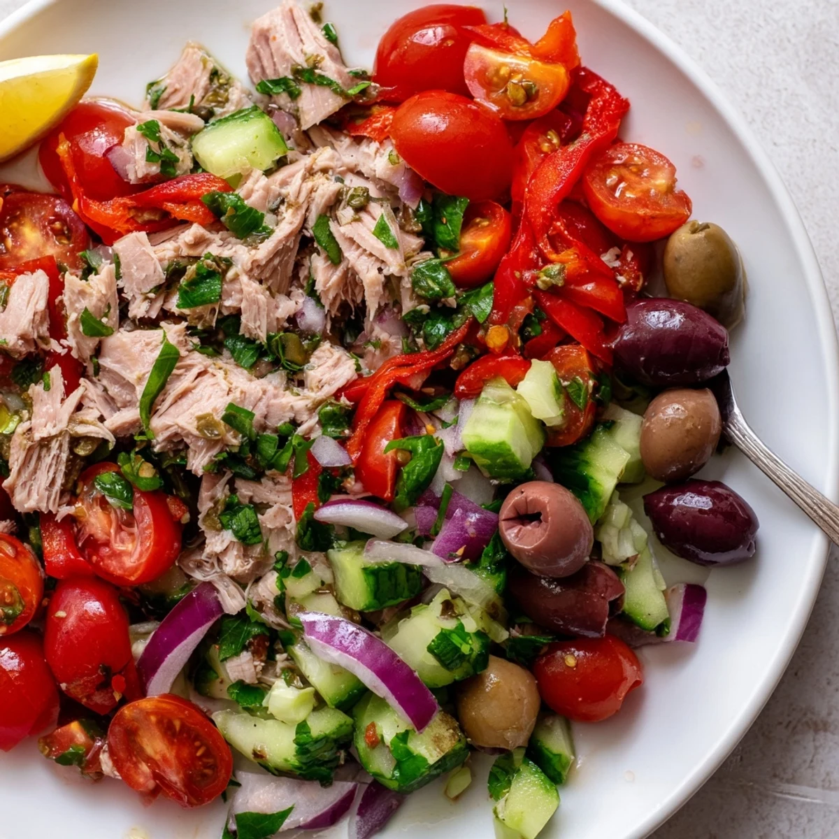 Simple Mediterranean Tuna Salad topped with olives, tomatoes, and a zesty lemon dressing