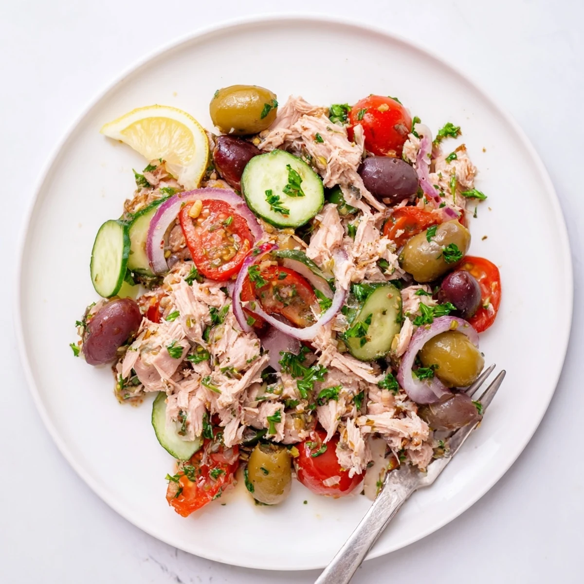 Simple Mediterranean Tuna Salad served on a rustic plate with fresh parsley and red onion