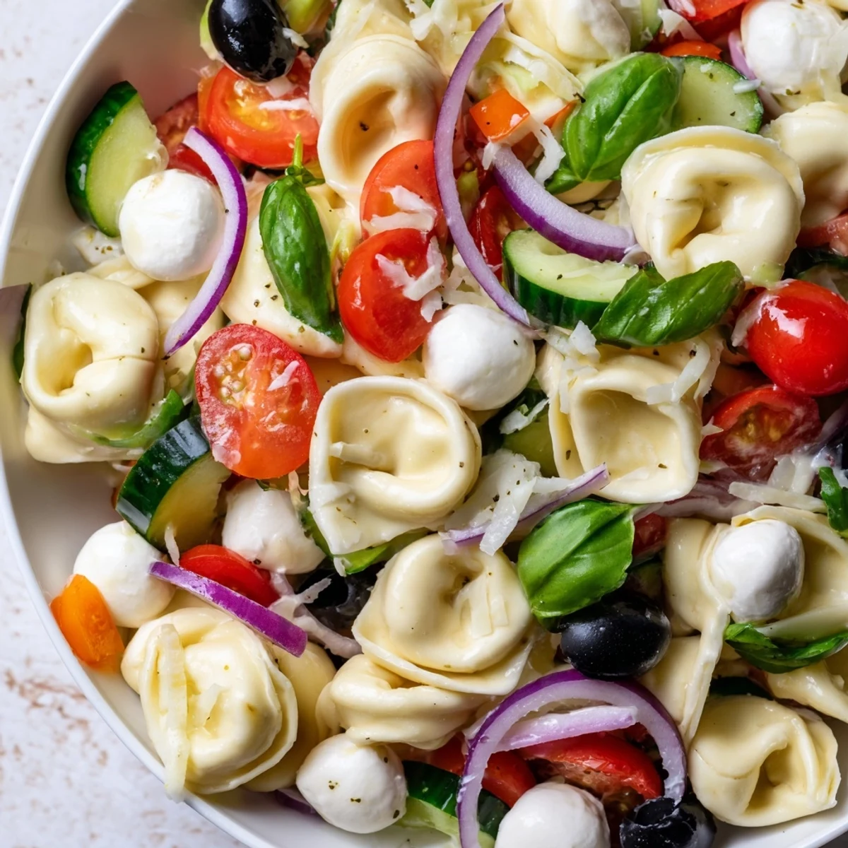 Cheese tortellini salad featuring crisp vegetables and fresh basil in a tangy vinaigrette
