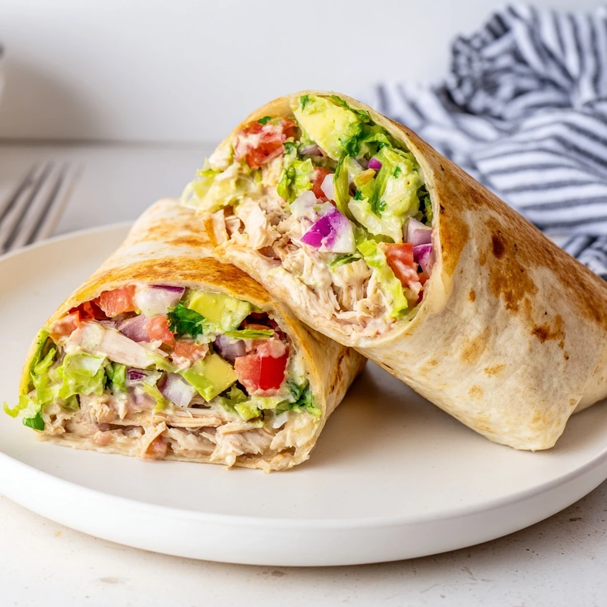 Toasty Chicken Avocado Ranch Burritos sliced to reveal creamy avocado and melted cheese