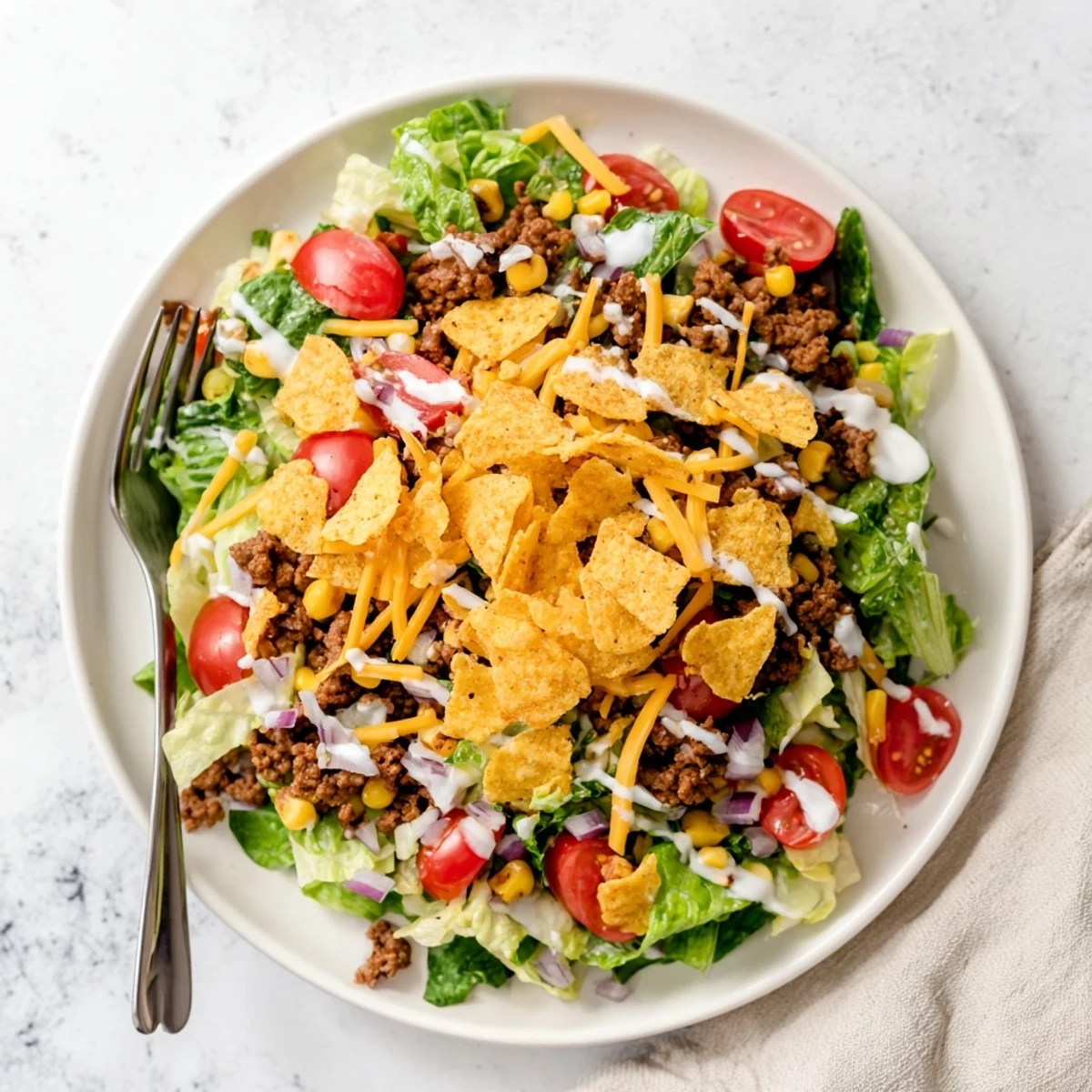 Colorful Simple Doritos Taco Salad topped with shredded cheddar and creamy ranch