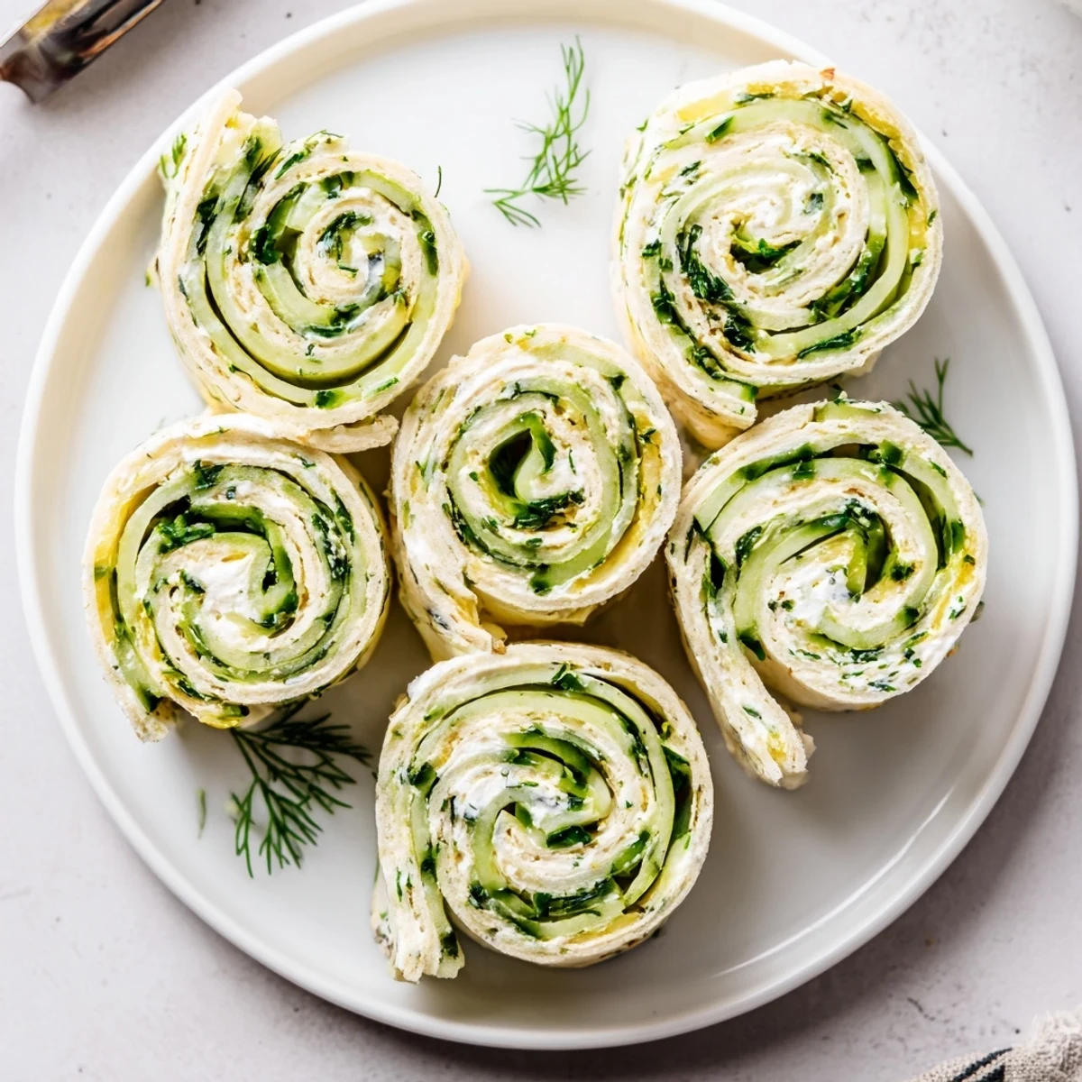 Easy Cucumber And Dill Pinwheels sliced into bite-sized spirals, refreshing party appetizer.
