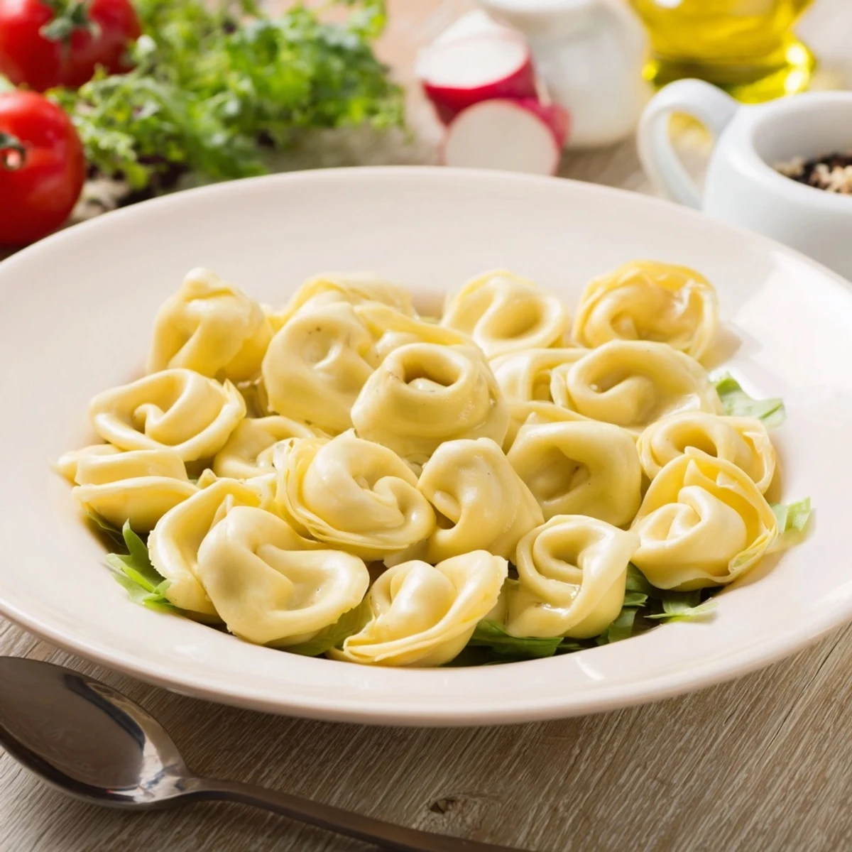 Chilled Tortellini Pasta Salad tossed in zesty Italian dressing, olives visible