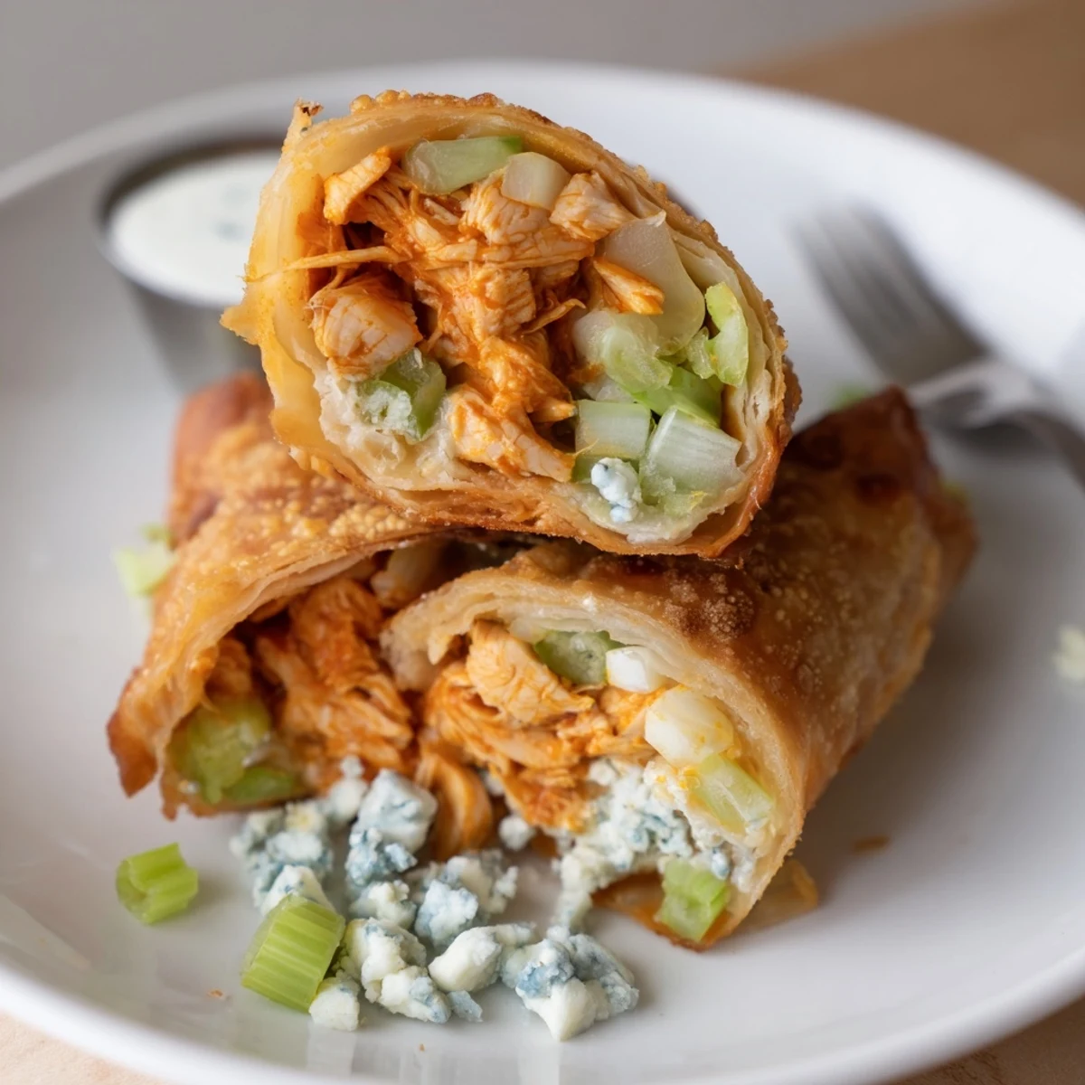 Golden-fried Buffalo Chicken Egg Rolls with celery crunch and blue cheese crumble.