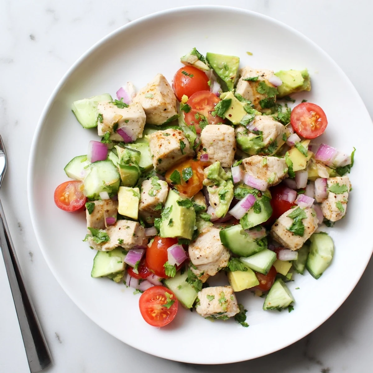 Fresh healthy avocado chicken salad bowl with grilled chicken, creamy avocado, and vibrant vegetables