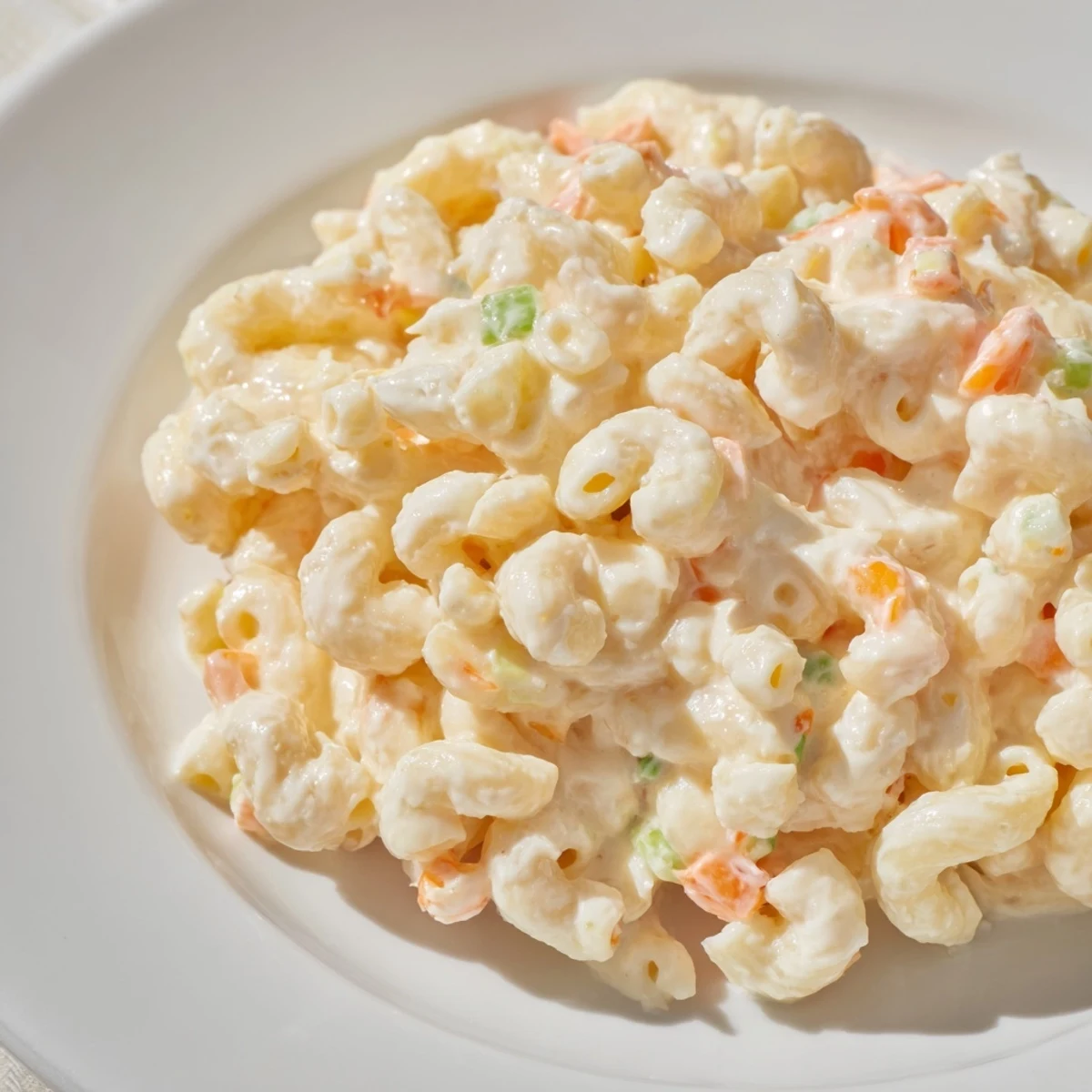 Creamy Hawaiian style mac salad featuring tender elbow macaroni tossed in tangy mayonnaise dressing with colorful grated carrot and celery bits