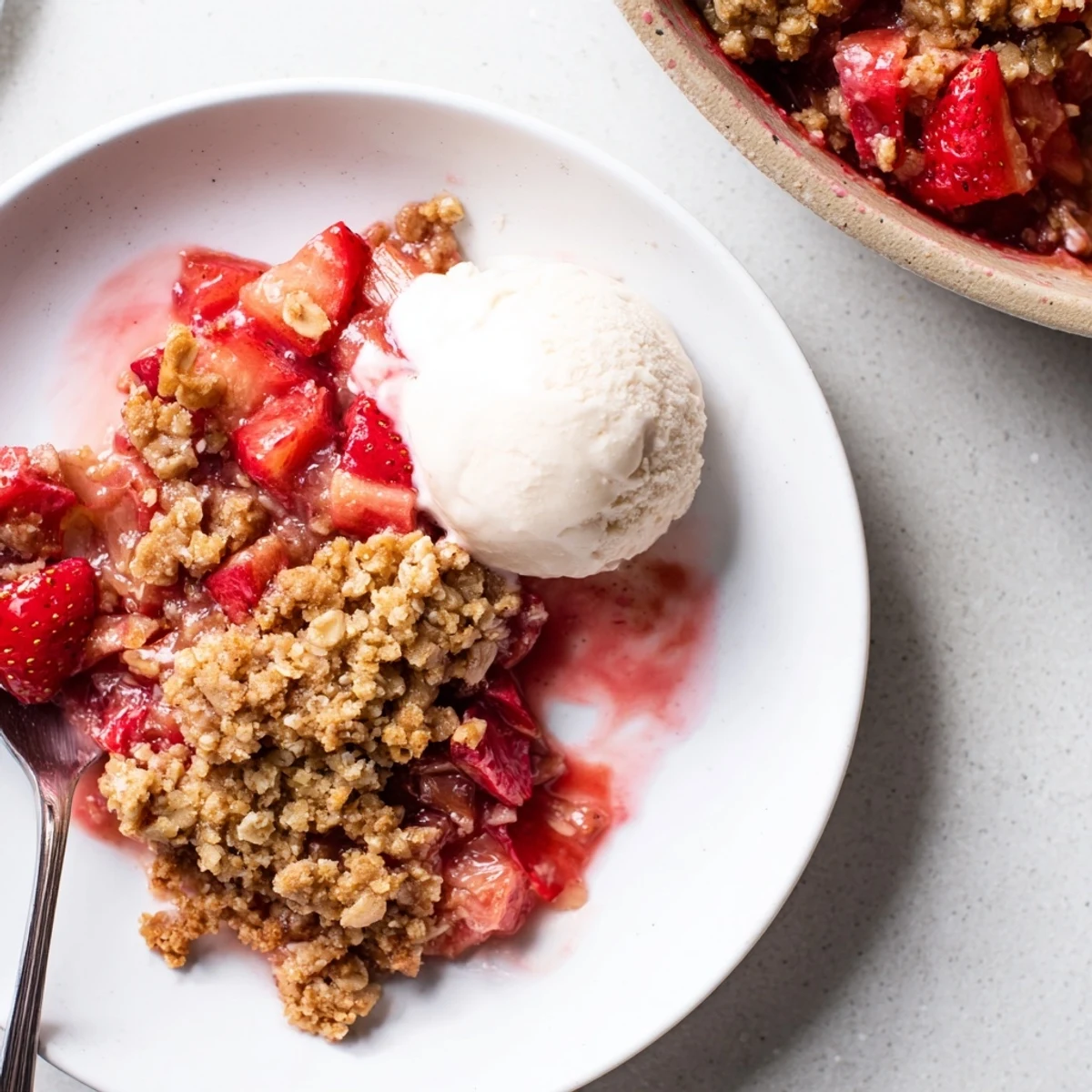 Homestyle Strawberry Rhubarb Crisp Recipe served warm with melting vanilla ice cream