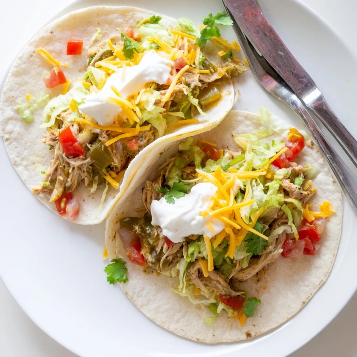 Juicy Slow Cooker Ranch Chicken Tacos loaded with melted cheddar and fresh cilantro