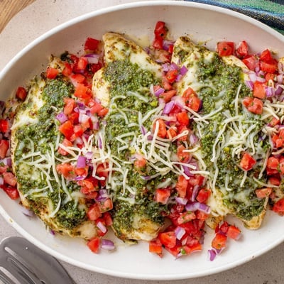Tender chicken breasts layered with green basil pesto and juicy tomato bruschetta topping