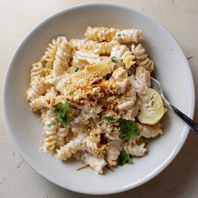 Bright Juicy Street Corn Pasta Salad tossed with cotija, smoky paprika, lime wedges